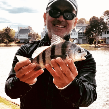 Dan with a fish by the water
