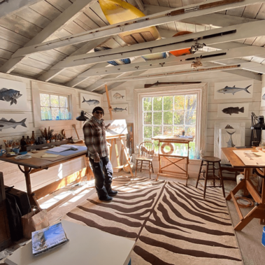 Dan in his studio with fish paintings on the walls